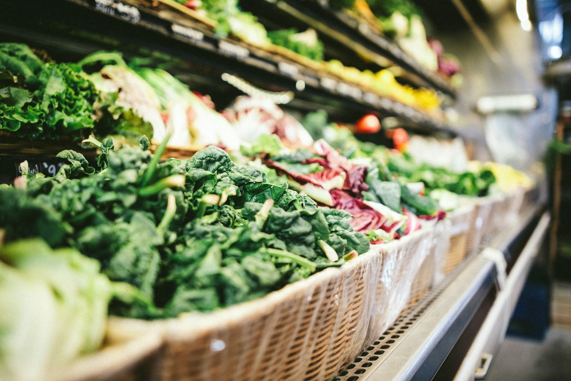 Fresh produce displayed in baskets on a grocery store shelf