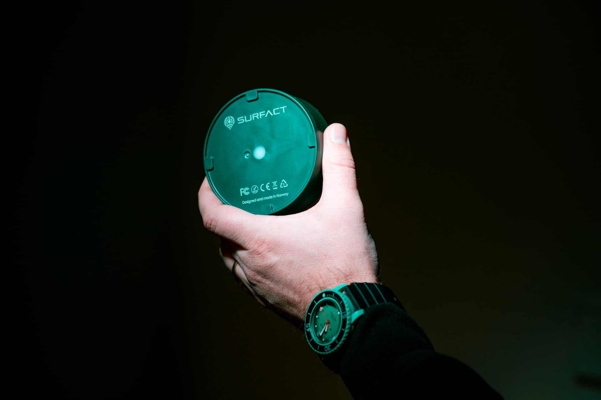 Emma Smart Tracker held in a hand, showing its recycled ocean plastic housing